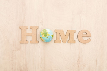 top view of wooden word home and toy planet on wooden background