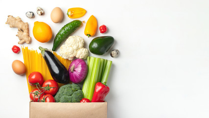 Paper bag of different health food on a table.