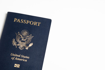 The iconic blue cover of an American passport deliberately and artistically set on a plain white background.