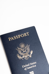 The iconic blue cover of an American passport deliberately and artistically set on a plain white background.
