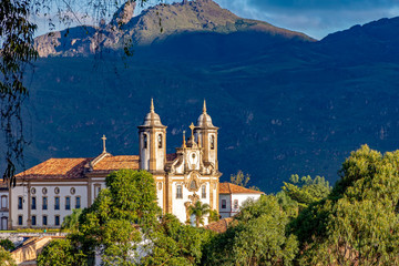 Fototapeta na wymiar Old catholic church of the 18th century located in the center of the famous and historical city of Ouro Preto in Minas Gerais with Itacolomy hill at background
