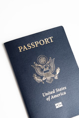 The iconic blue cover of an American passport deliberately and artistically set on a plain white background.