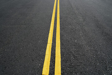 double yellow lines on new paved asphalt road surface