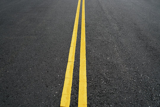 double yellow lines on new paved asphalt road surface