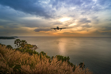 scenic of air plane prepare landing with seascape sunset skyline