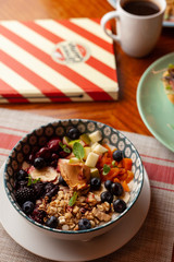 Rich oatmeal with fresh berries, nuts, fruit and peanut butter