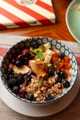 Rich oatmeal with fresh berries, nuts, fruit and peanut butter