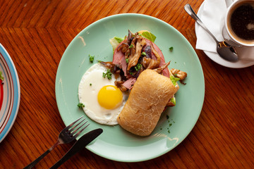 Ciabatta with oyster mushrooms, ham and fried egg for breakfast