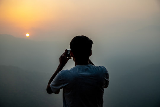 man taking pictures on mobile phone