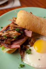 Ciabatta with oyster mushrooms, ham and fried egg for breakfast