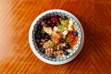 Rich oatmeal with fresh berries, nuts, fruit and peanut butter