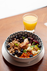 Rich oatmeal with fresh berries, nuts, fruit and peanut butter