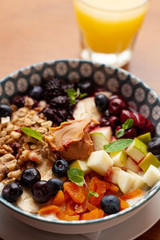 Rich oatmeal with fresh berries, nuts, fruit and peanut butter