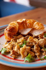 Lush croissant with chicken, soft cream cheese and scramble