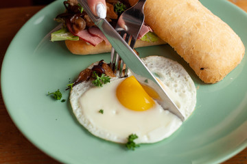 Ciabatta with oyster mushrooms, ham and fried egg for breakfast