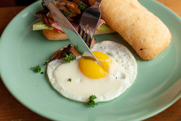 Ciabatta with oyster mushrooms, ham and fried egg for breakfast