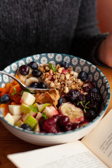 Rich oatmeal with fresh berries, nuts, fruit and peanut butter