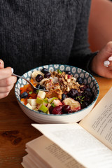 Rich oatmeal with fresh berries, nuts, fruit and peanut butter