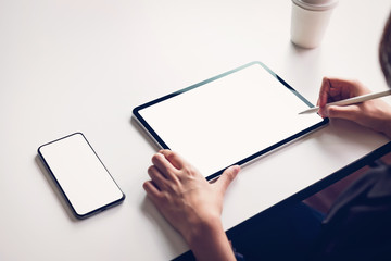 Woman using tablet screen blank on the table mock up to promote your products. Concept of future and trend internet for easy access to information.