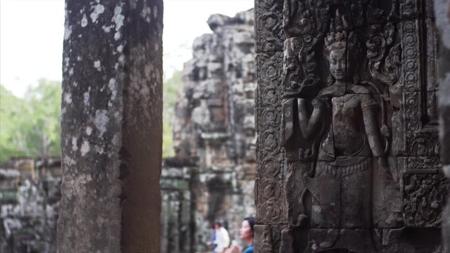 Sliding view of deity carvings on the stone wall at Bayon Temple, a Khmer temple at Angkor in Cambodia built in the late 12th century and richly decorated