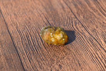 Stone of gallbladder. The result of gallstones. A calculus of dissimilar composition on a wooden background.