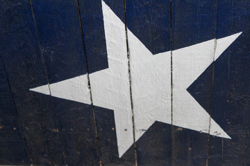 White Star and blue background painted on wooden sign