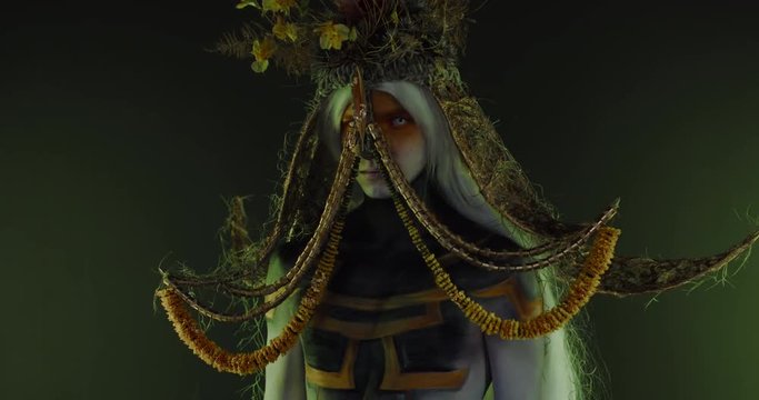 Portrait of Caucasian male with complex warrior floral make-up posing in creative lighting. Body painting fashion project. Model and property released