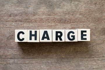 Fototapeta premium Letter block in word charge on wood background