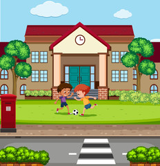 Boys playing fooyball in front of school