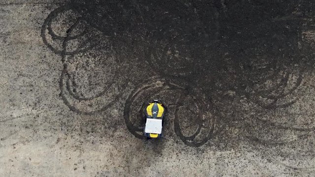 Aerial photography UTV, riding in a circle , throwing dirt on the field . shooting with the drone , slowing