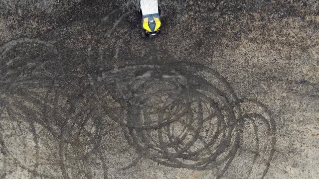 Aerial photography UTV, riding in a circle , throwing dirt on the field . shooting with the drone , slowing