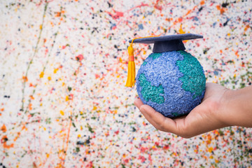 Education world study abroad educational knowledge idea. Graduation cap on Businessman holding...