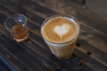a cup of latte art coffee on wooden background