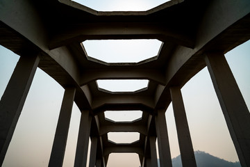Fototapeta premium Close-up of a white railroad bridge looking up from the inside against white and blue sky background.