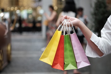 Young woman holding sale shopping bags. consumerism lifestyle concept in the shopping mall