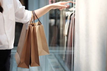 Young woman holding sale shopping bags. consumerism lifestyle concept in the shopping mall