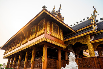 Fototapeta premium Beautiful Lanna style wooden building on a sunny day with sun beam at a Buddhist temple in Thailand.