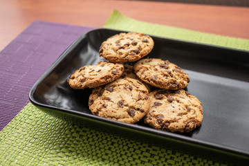Delicious chocolate chip cookies on black plate