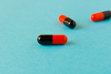 Few pills scattered on blue background . Birth control pills. Selective focus.