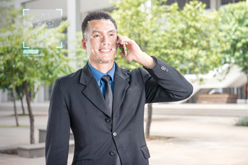Smiling asian businessman with mobile phone using face recognition