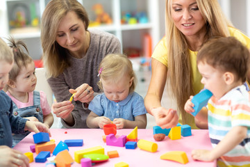 Kindergarten kids play at with teacher and educator