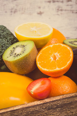 Heap of ripe fruits with vegetables in rustic box. Nutritious food containing healthy minerals and vitamins. Vintage photo