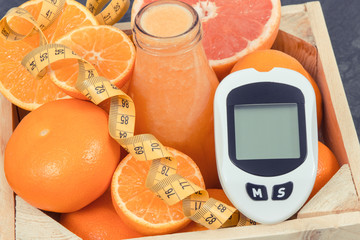 Glucose meter for measuring sugar level, freshly blended coctail from citrus and centimeter....