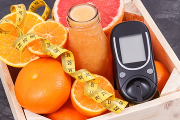 Glucose meter for measuring sugar level, freshly blended coctail from citrus and centimeter....