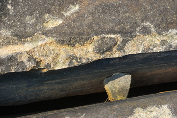 The currents erode the rock until breaking.