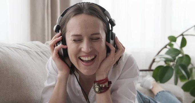 Happy woman listening to music on sofa at home