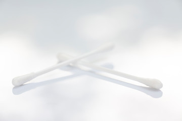 Two white plastic cotton buds on white table texture background, Close up & Macro shot, Selective focus, Light & shadow, About Cleaning Body, Healthcare concept