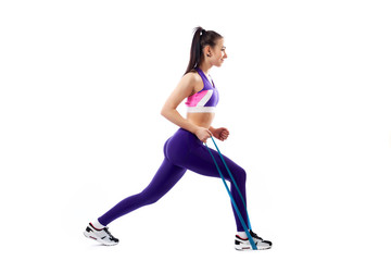 Sporty woman does  exercises on legs, makes lunges  with sport fitness rubber bands  on white background. Photo of muscular woman in sportswear on white background. Strength and motivation.