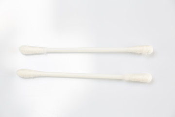 Two white plastic cotton buds on white table texture background, Close up & Macro shot, Selective focus, Light & shadow, About Cleaning Body, Healthcare concept