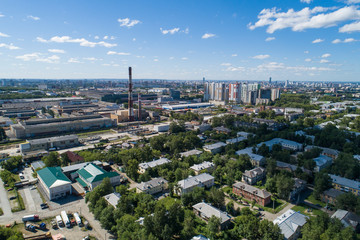 Fototapeta premium Top down aerial drone image of a Ekaterinburg city and plant in the midst of summer, backyard turf grass and trees lush green.
